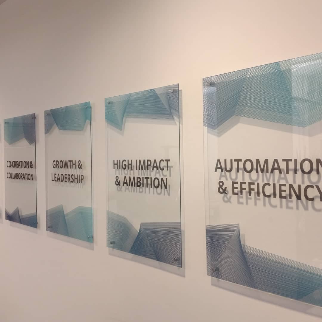 6 glass panels with company values printed transparently, mounted in office with shadow effect